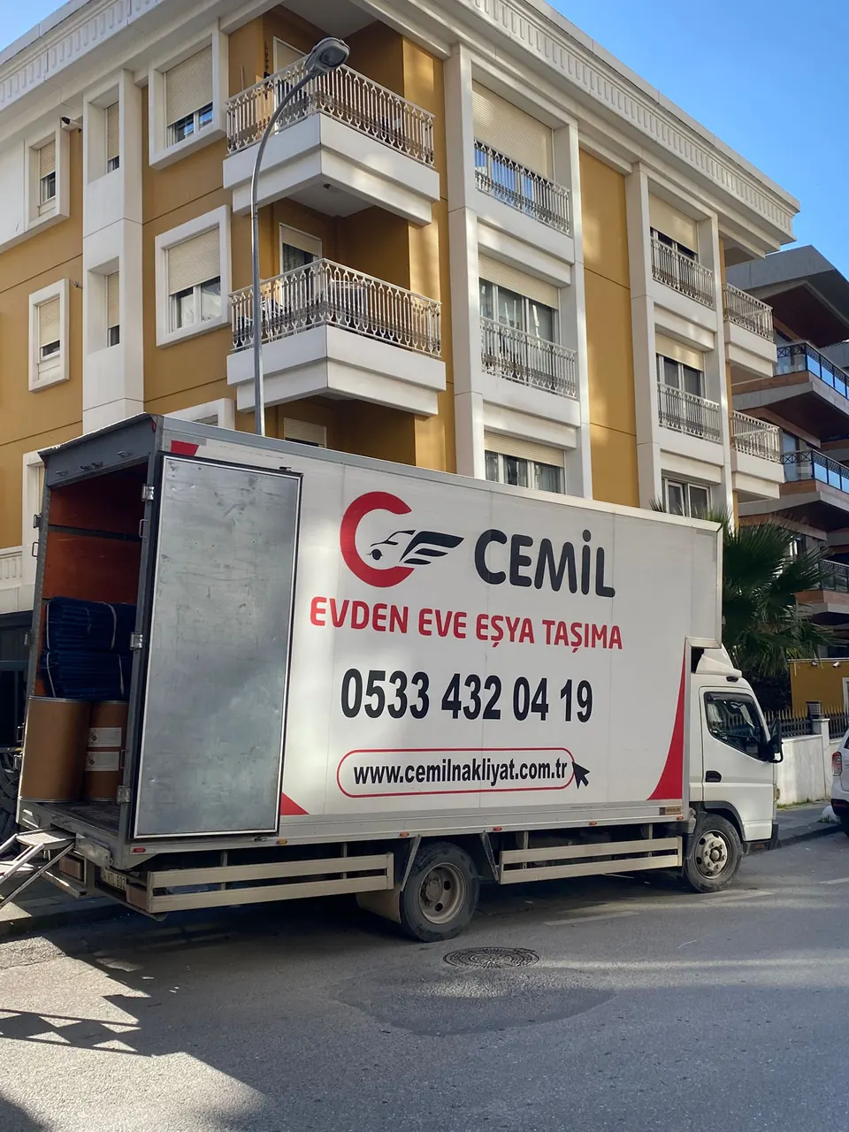 Bina önünde Cemil Nakliyat aracı yükleme çalışması